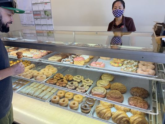 The full donut display case at Family Donut Shop, every shelf filled